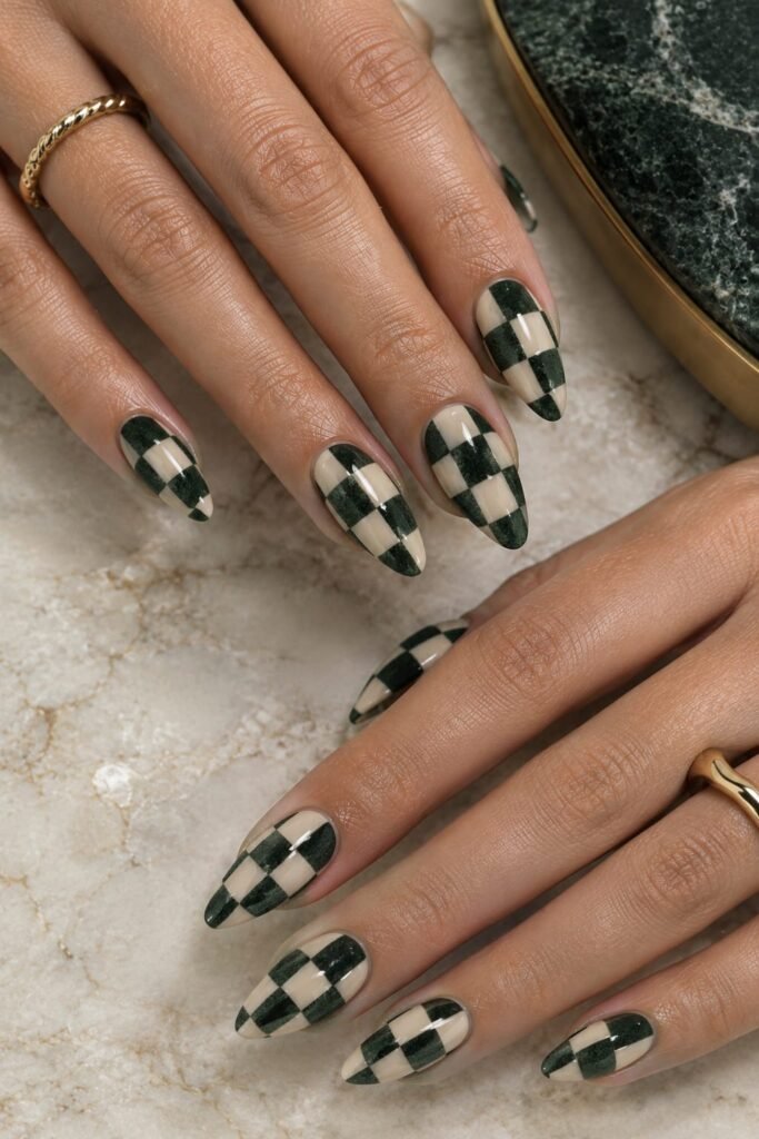Almond nails featuring deep green velvet and creamy beige checkerboard nail art.