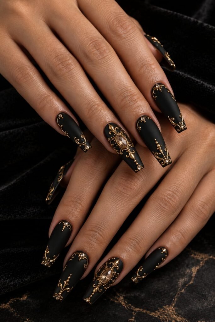 Black matte Baroque nails with raised gold scrollwork and champagne embellishments.