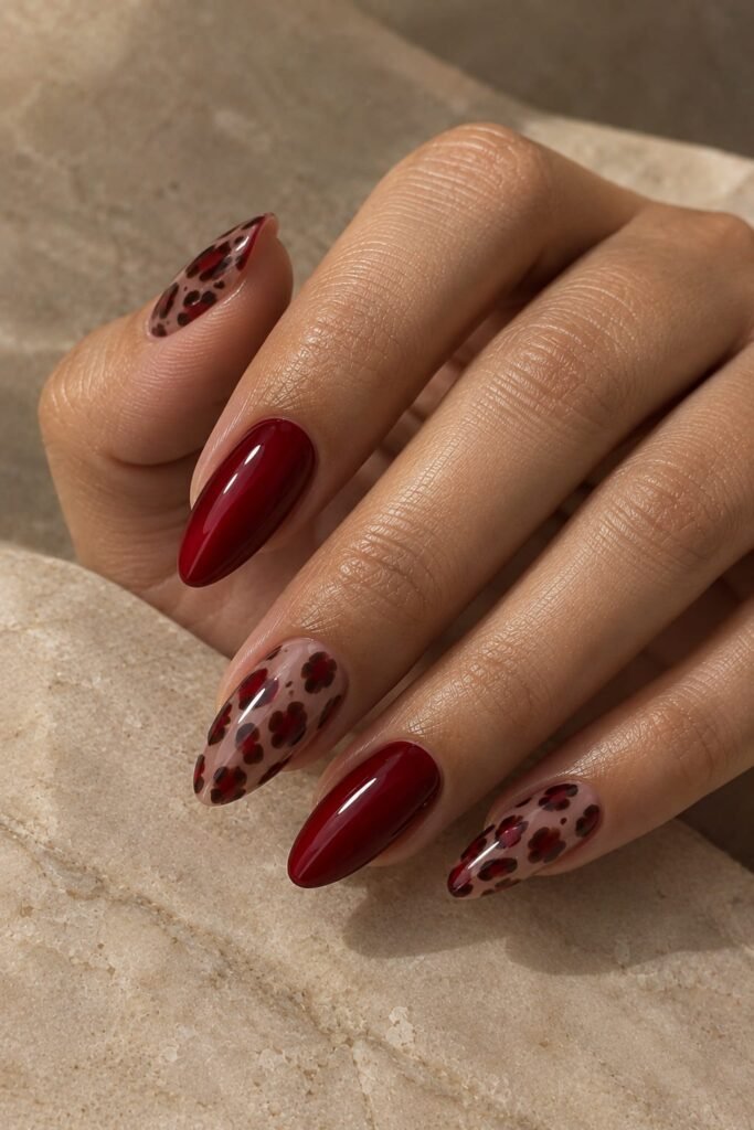 Cherry red almond nails with translucent animal-print accent details