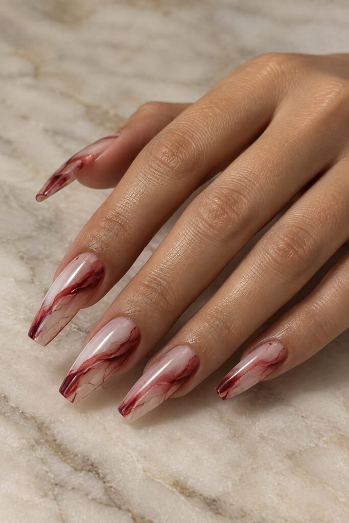 Cherry red and milky marble nails with delicate flowing veining
