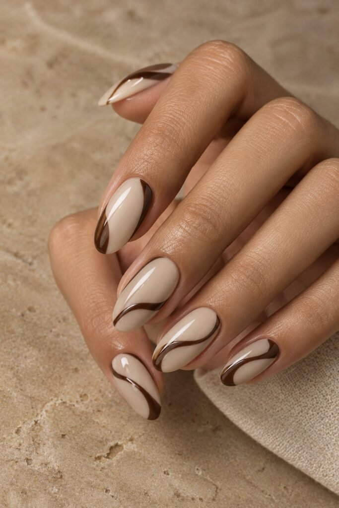 Creamy beige oval nails with chocolate brown abstract swirls