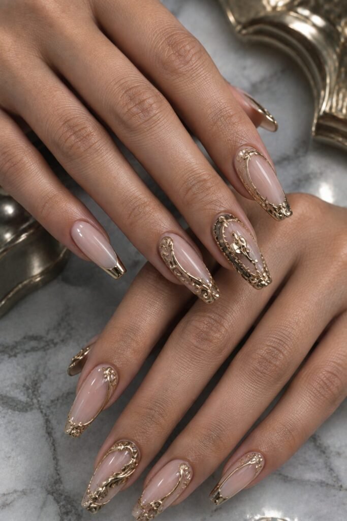 Gold chrome 3D Baroque nails with sculpted raised scrollwork over a nude base.