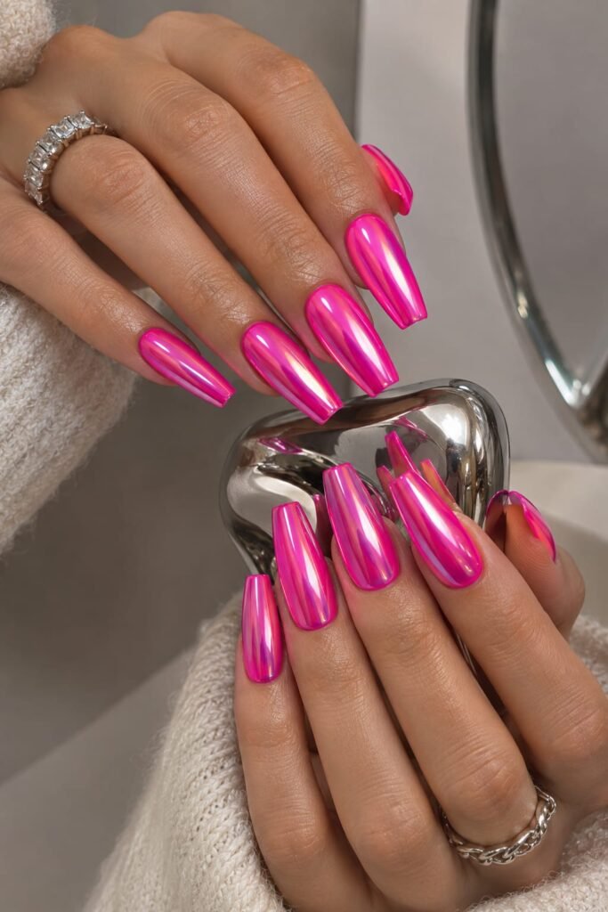 Hot pink neon chrome nails with a glossy metallic finish on long coffin nails.