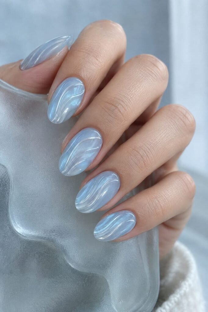 Icy blue ribbed glass nails with curved glossy wave lines