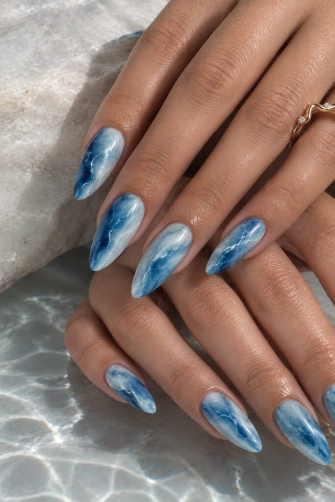 Long almond ocean marble nails with cobalt blue, aqua, and white flowing veins