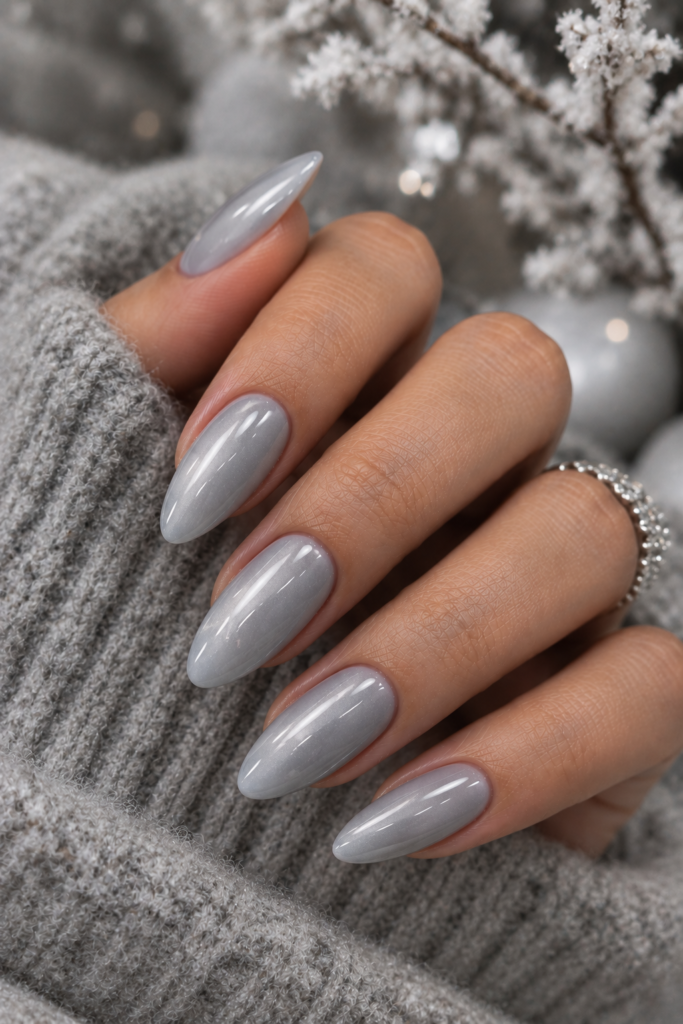 Long oval nails painted in soft pearl gray with a glossy winter-inspired finish.