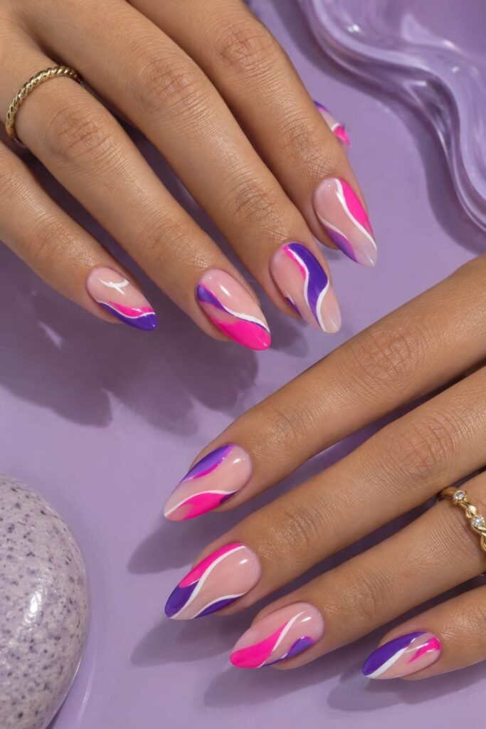 Neon pink and purple abstract nails with modern colorful curved nail art.