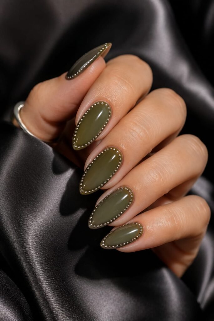 Olive green almond nails outlined with precision silver metallic dots.