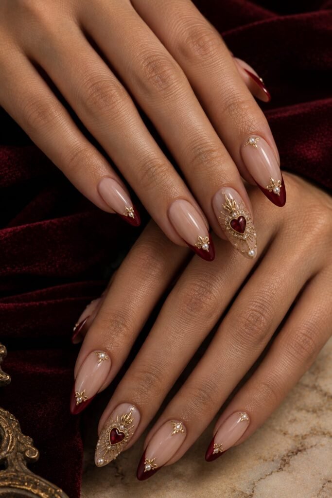 Ruby sacred-heart Baroque nails framed with raised gold rays and pearls.