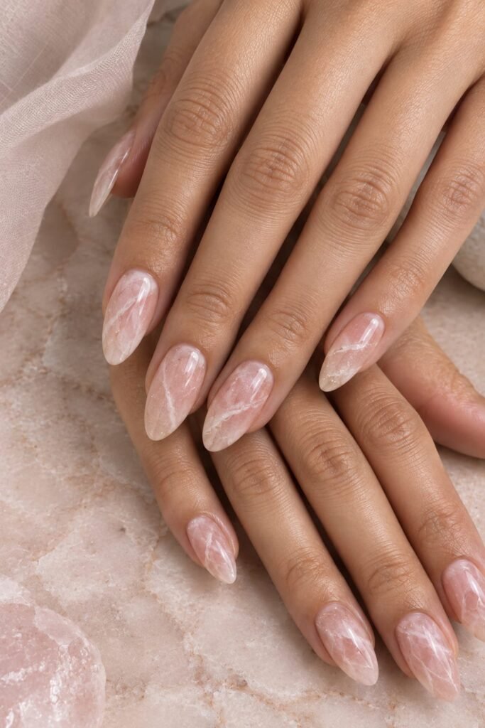 Translucent pink almond marble nails inspired by rose quartz with white veining